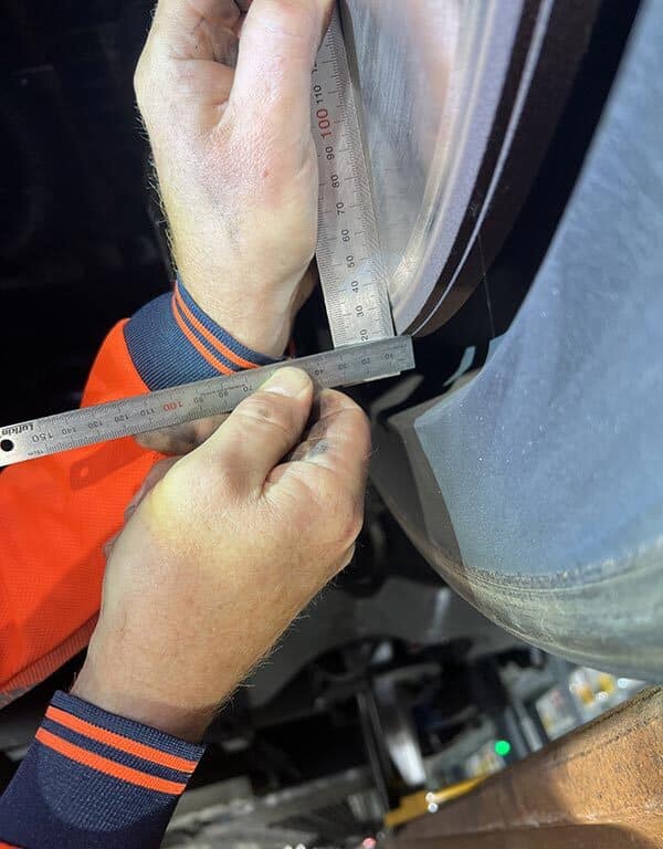 wheel being measured by a rail engineering during a passenger vehicle maintenance audit